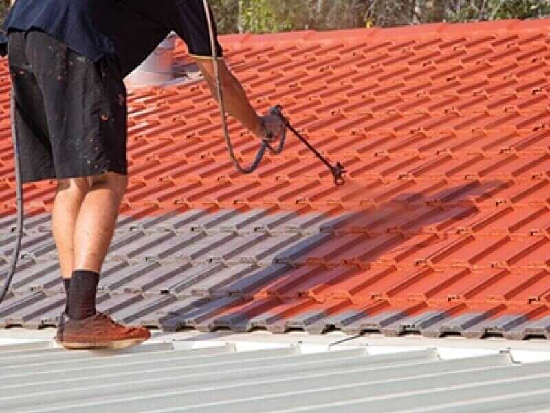 Person Painting A Roof Tile With An Airless Sprayer